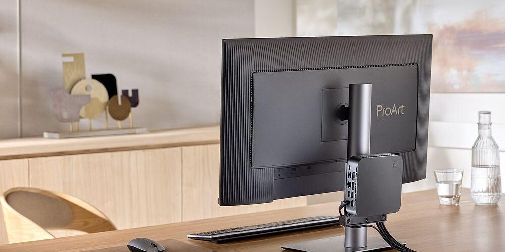 ASUS ExpertCenter PN55 Mini-PC von vorne links, auf einer minimalistischen Oberfläche.